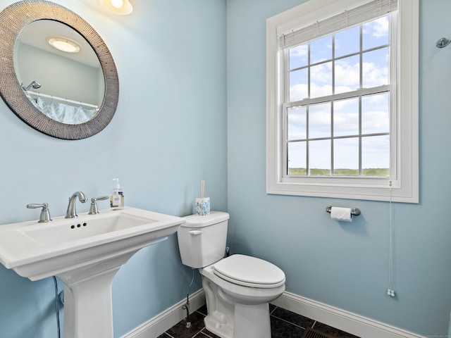 full bath with baseboards, tile patterned flooring, toilet, and plenty of natural light