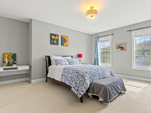 carpeted bedroom featuring baseboards and multiple windows