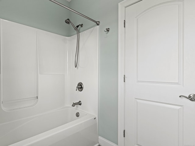 bathroom with shower / washtub combination and baseboards