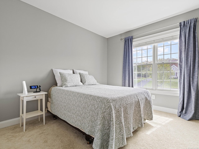 bedroom with light carpet and baseboards