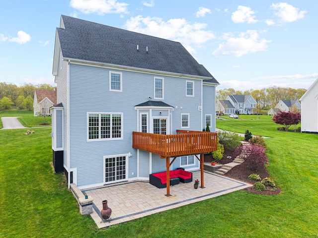 rear view of property featuring a yard, roof with shingles, a patio area, and a deck