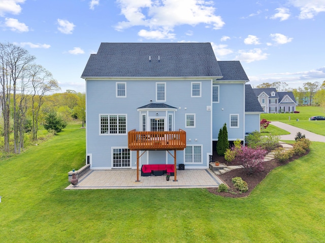 rear view of property featuring a lawn, a patio, and a wooden deck