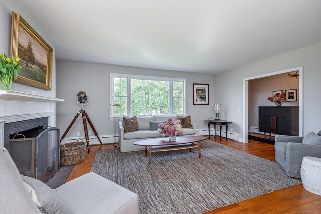 108 E St, Washington, CT 06793 - living room featuring baseboards, baseboard heating, a fireplace, and wood finished floors