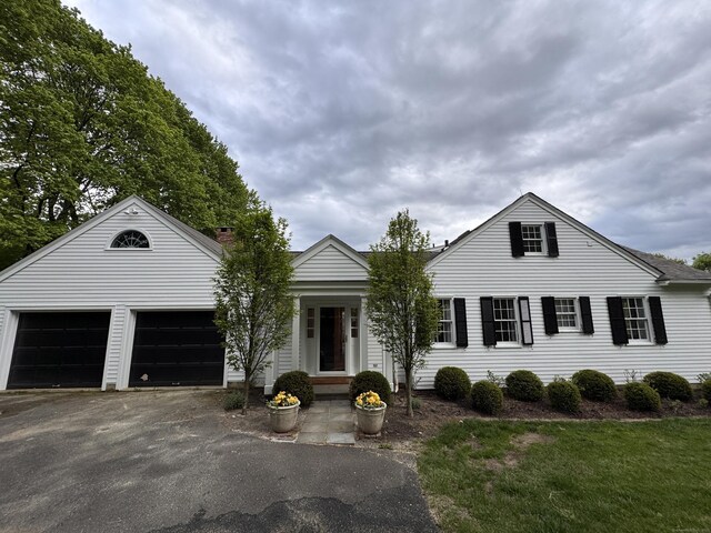 108 E St, Washington, CT 06793 - view of front of house with driveway, a garage, and a front lawn