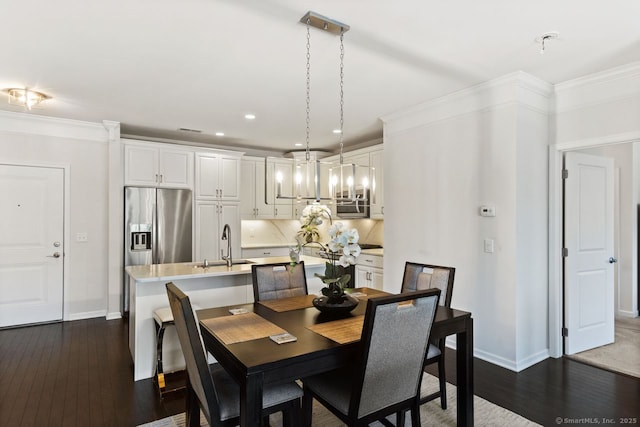 dining space with dark wood-style flooring, crown molding, baseboards, a chandelier, and recessed lighting
