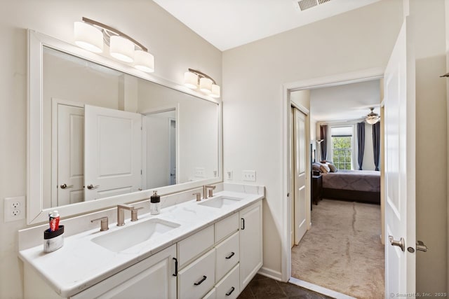 full bath featuring double vanity, baseboards, a sink, and ensuite bathroom