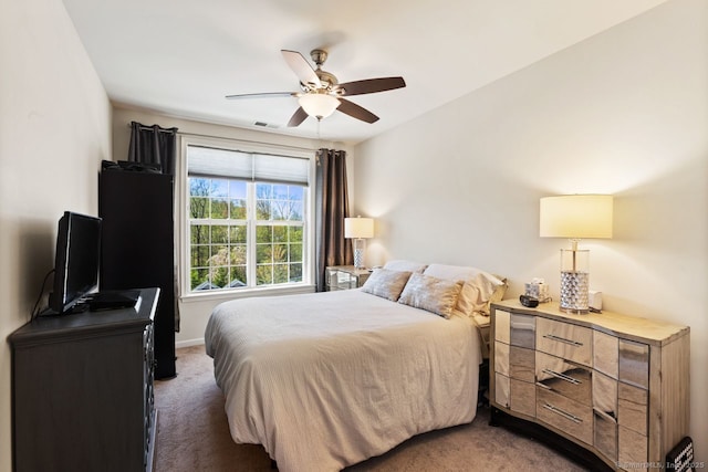 carpeted bedroom with a ceiling fan, baseboards, and visible vents