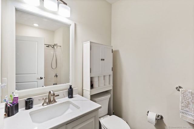 full bath featuring vanity, a shower, and toilet