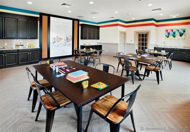 dining area featuring visible vents, recessed lighting, and a community bar
