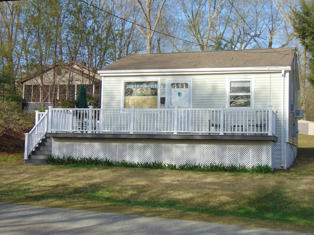 rear view of property with a lawn and a wooden deck