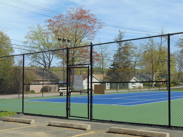 view of tennis court featuring fence