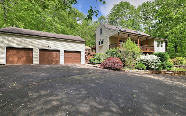 1540 Paradise Ave, Hamden, CT 06514 - view of front facade featuring an outbuilding, a detached garage, view of scattered trees, and roof with shingles