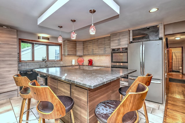 1540 Paradise Ave, Hamden, CT 06514 - kitchen featuring appliances with stainless steel finishes, a raised ceiling, a sink, tasteful backsplash, and a center island