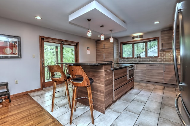 1540 Paradise Ave, Hamden, CT 06514 - kitchen featuring a kitchen bar, modern cabinets, healthy amount of natural light, recessed lighting, and decorative backsplash