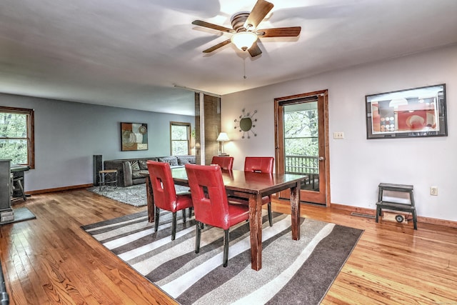 1540 Paradise Ave, Hamden, CT 06514 - dining room featuring a wood stove, hardwood / wood-style floors, a ceiling fan, and baseboards