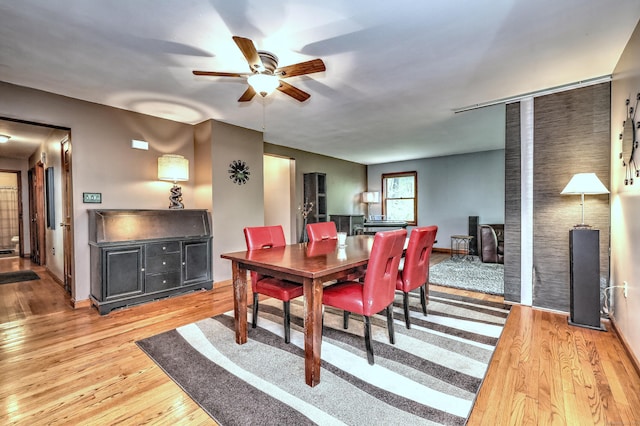 1540 Paradise Ave, Hamden, CT 06514 - dining room with a ceiling fan, light wood-style floors, baseboards, and a wood stove