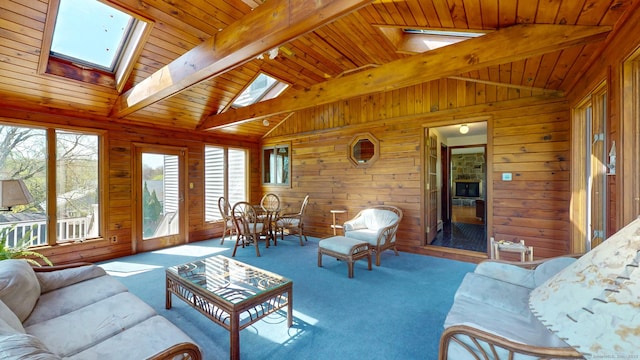 living area featuring wooden ceiling, wood walls, carpet, and vaulted ceiling with skylight