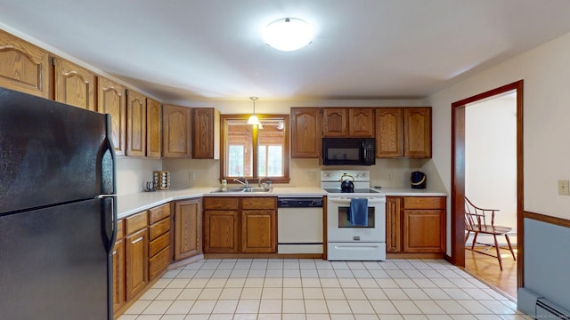 kitchen with brown cabinets, a sink, light countertops, a baseboard radiator, and black appliances