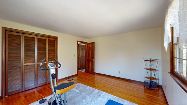 workout area featuring baseboards and wood finished floors