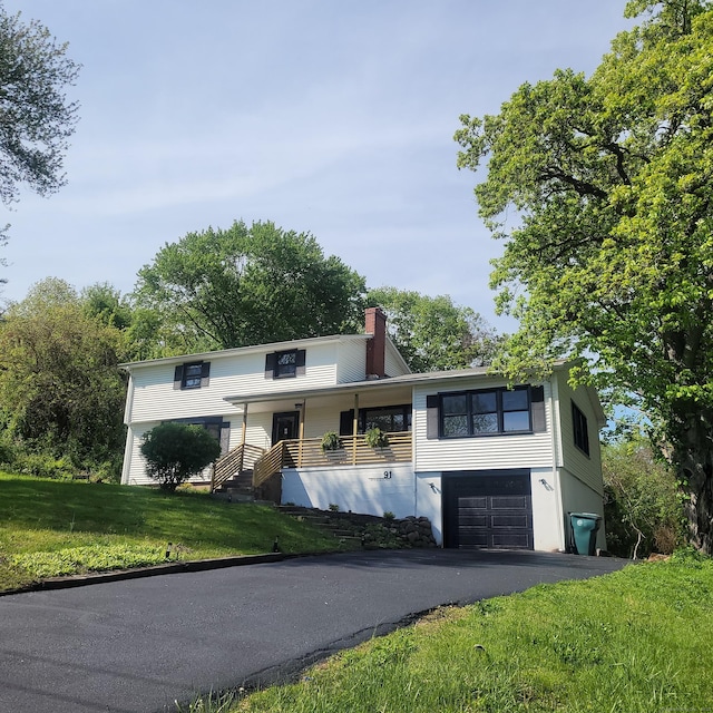 91 Jennifer Rd, Hamden, CT 06514 - view of front of house with a garage, driveway, a front yard, and a chimney