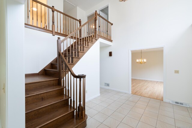39 Amato Cir, Southington, CT 06489 - stairs featuring a chandelier, a high ceiling, baseboards, and tile patterned flooring