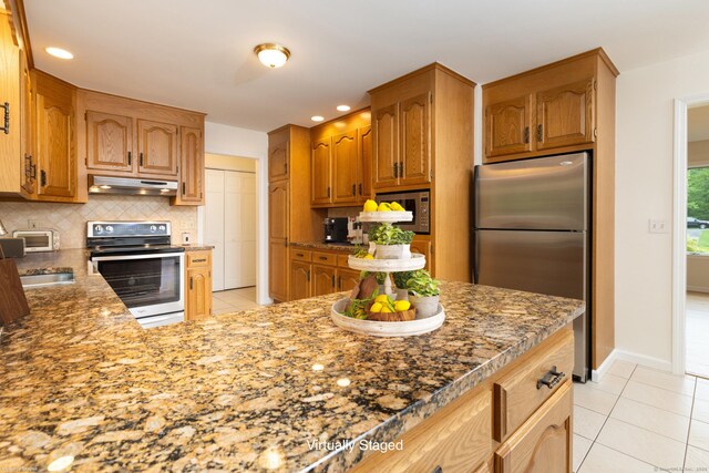 39 Amato Cir, Southington, CT 06489 - kitchen with stainless steel appliances, under cabinet range hood, light tile patterned floors, tasteful backsplash, and a sink