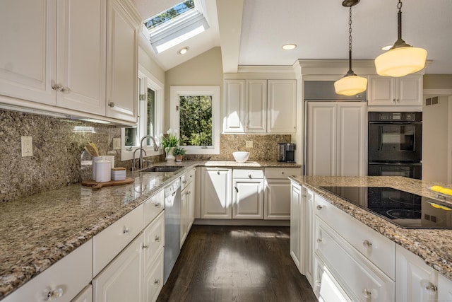 kitchen with light stone countertops, hanging light fixtures, a sink, dark wood-type flooring, and black appliances
