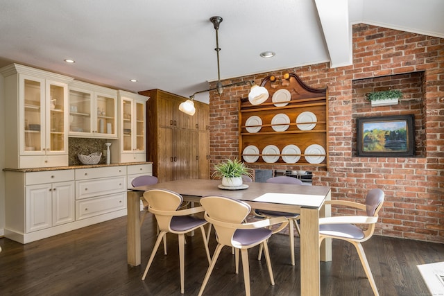 dining space with recessed lighting, dark wood-style flooring, brick wall, and lofted ceiling