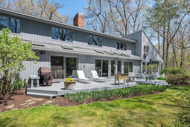 back of house with a yard, a chimney, and a deck