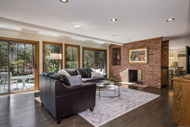 living area with recessed lighting, a fireplace, dark wood finished floors, and a wealth of natural light