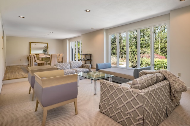 carpeted living area with recessed lighting and baseboards