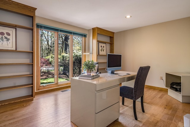 office space featuring recessed lighting, baseboards, and light wood-type flooring