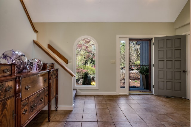 entryway with stairs, tile patterned floors, vaulted ceiling, and baseboards