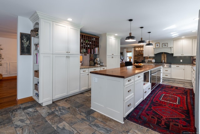 130 Upper Whittemore Rd, Middlebury, CT 06762 - kitchen featuring pendant lighting, wooden counters, a center island, white cabinetry, and stone finish flooring
