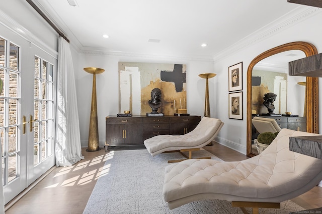 sitting room with french doors, wood finished floors, baseboards, ornamental molding, and recessed lighting