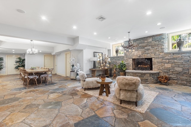 living room with visible vents, stone flooring, a notable chandelier, and recessed lighting