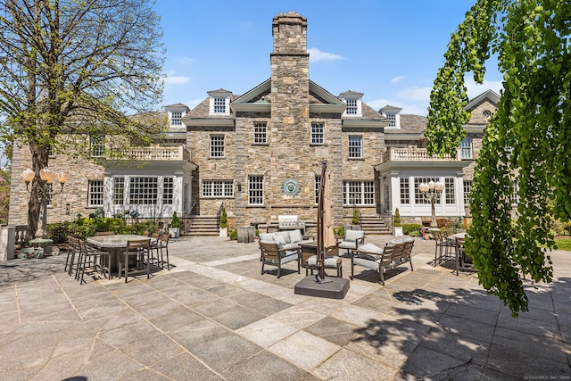 view of patio / terrace featuring an outdoor living space, outdoor dining area, and a balcony