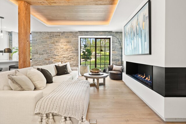 41 Richmondville Ave Unit 206, Westport, CT 06880 - living room with light wood-style flooring, a raised ceiling, a warm lit fireplace, and wood ceiling