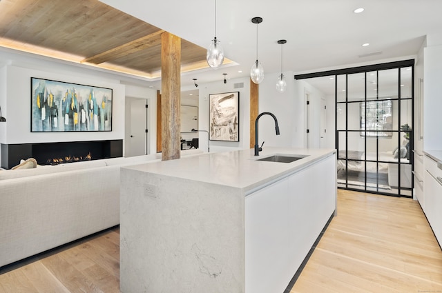 41 Richmondville Ave Unit 206, Westport, CT 06880 - kitchen featuring a sink, light wood-style flooring, wood ceiling, decorative light fixtures, and open floor plan