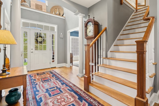 entryway featuring plenty of natural light, stairway, and wood finished floors