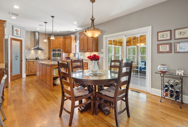 dining room with light wood-style floors, recessed lighting, and baseboards