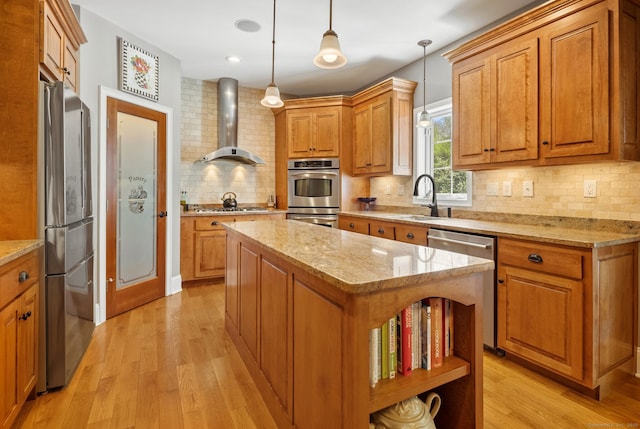 kitchen with wall chimney range hood, open shelves, a sink, stainless steel appliances, and brown cabinetry