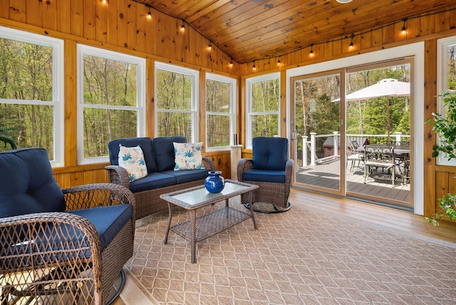sunroom featuring vaulted ceiling, an outdoor living space, and outdoor dining space