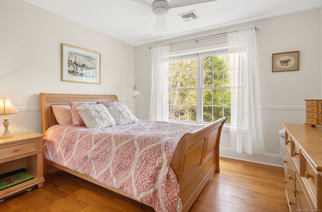 bedroom featuring light wood finished floors, a ceiling fan, and baseboards