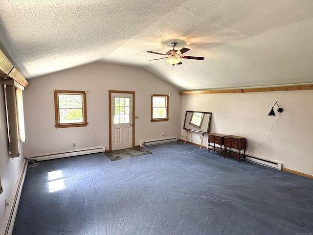 additional living space featuring ceiling fan, a baseboard heating unit, dark carpet, and lofted ceiling