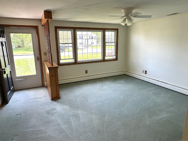 empty room with carpet, a ceiling fan, a baseboard heating unit, and a wealth of natural light