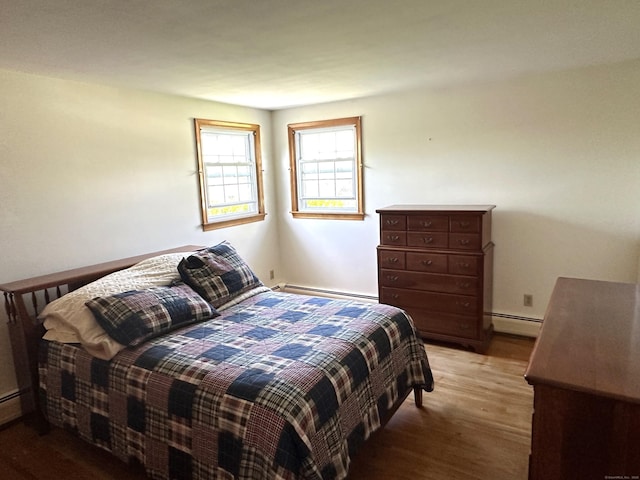 bedroom with a baseboard radiator and wood finished floors