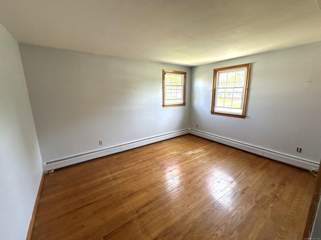 spare room with baseboards and wood finished floors