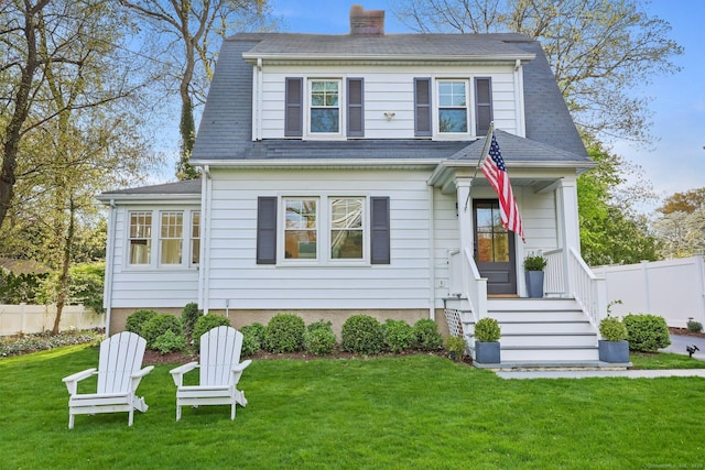 view of front of house featuring a front lawn, fence, and a chimney