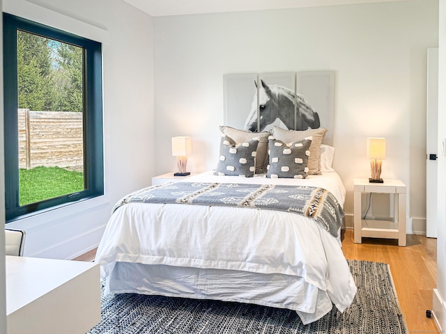 bedroom with baseboards and wood finished floors